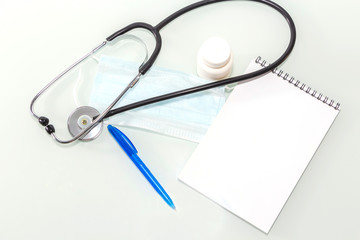 Stethoscope in the office of doctors.Top view of doctor's desk table, blank paper on clipboard with pen. Copy space.