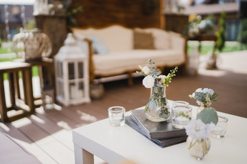 Coziness and style. Modern event design. Lounge and photo zone and european traditional wedding ceremony decoration outdoors in the restaurant before the reception.