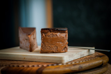 Burnt chocolate cheesecake on brown wooden background. selective focus
