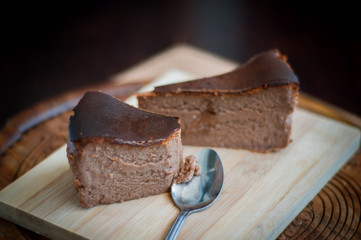 Burnt chocolate cheesecake on brown wooden background. selective focus