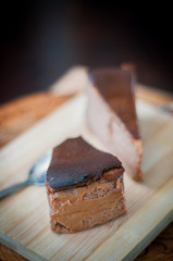 Burnt chocolate cheesecake on brown wooden background. selective focus