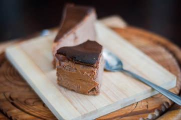 Burnt chocolate cheesecake on brown wooden background. selective focus