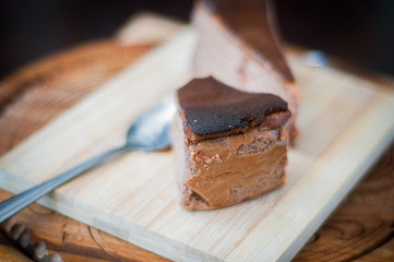 Burnt chocolate cheesecake on brown wooden background. selective focus