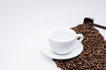 white cup of coffee with coffee bean and spoon on white background