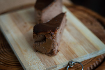 Burnt chocolate cheesecake on brown wooden background. selective focus
