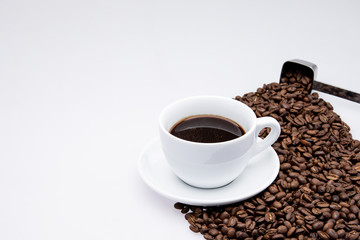 white cup of coffee with coffee bean and spoon on white background
