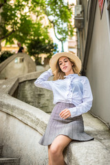 Beautiful girl sits on wall