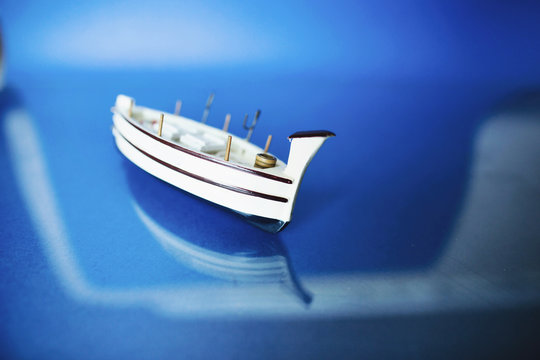 White little toy ship with shells on a blue background