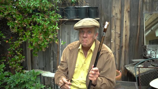 Crabby anf grumpy old man threatening with his cane