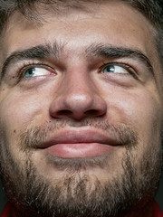 Fototapeta premium Close up portrait of young and emotional caucasian man. Highly detail photoshot of male model with well-kept skin and bright facial expression. Concept of human emotions. Smiling and looks happy.