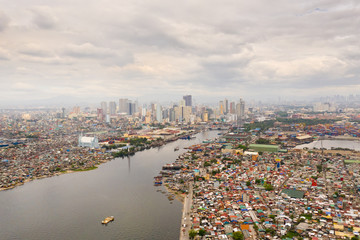 Fototapeta na wymiar Cityscape Manila. Residential areas and business center in the city, top view. Big port city. The capital of the Philippines. Contrast social strata.