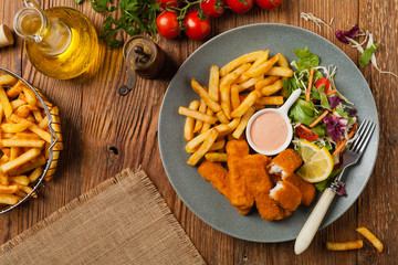 Fish sticks with fries and salad.