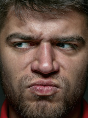 Fototapeta premium Close up portrait of young and emotional caucasian man. Highly detail photoshot of male model with well-kept skin and bright facial expression. Concept of human emotions. Angry, agressive.