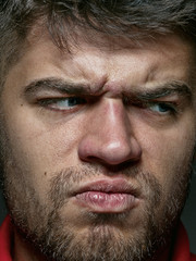 Obraz premium Close up portrait of young and emotional caucasian man. Highly detail photoshot of male model with well-kept skin and bright facial expression. Concept of human emotions. Angry, agressive.