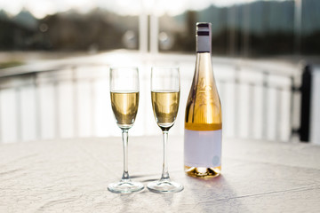 Romantic luxury evening with pair glass of champagne and bottle. Two romantic glasses of sparkling champagne alongside a bottle in luxury copy space to celebrate a wedding, anniversary, New Year