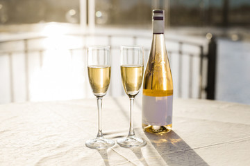 Romantic luxury evening with pair glass of champagne and bottle. Two romantic glasses of sparkling champagne alongside a bottle in luxury copy space to celebrate a wedding, anniversary, New Year