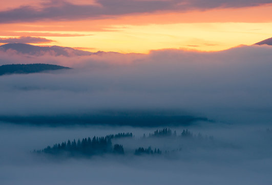 Sunrise in foggy mountains