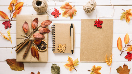 Colorful composition with autumn leaves, gift and notebook