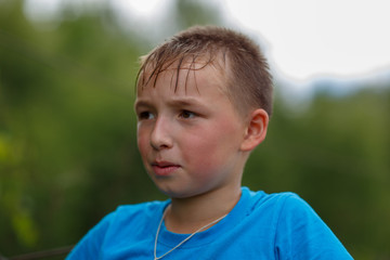 a boy in a blue t-shirt ,shot on a cloudy summer day