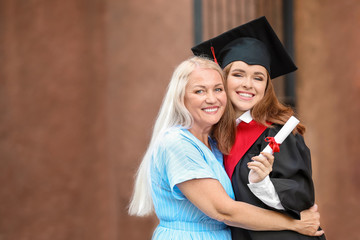 Happy young woman with her mother on graduation day
