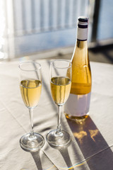 Romantic luxury evening with pair glass of champagne and bottle. Two romantic glasses of sparkling champagne alongside a bottle in luxury copy space to celebrate a wedding, anniversary, New Year