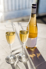 Champagne for romantic celebrations and enjoy for special moments. Two romantic glasses of sparkling champagne alongside a bottle in copy space to celebrate a wedding, anniversary, New year