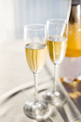 Romantic luxury evening with pair glass of champagne and bottle. Two romantic glasses of sparkling champagne alongside a bottle in luxury copy space to celebrate a wedding, anniversary, New Year