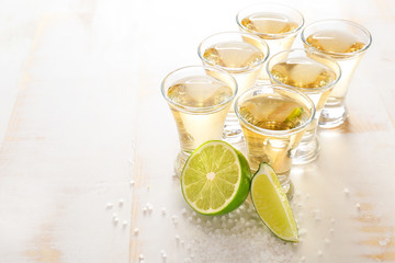 Shots of tequila on wooden background