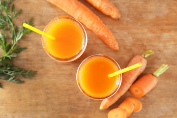 Jars of tasty carrot juice on wooden table