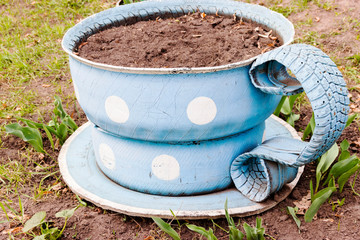 Flowerbed in the form of a tea set of old automobile tires