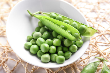 Bowl with tasty fresh peas on light background, closeup