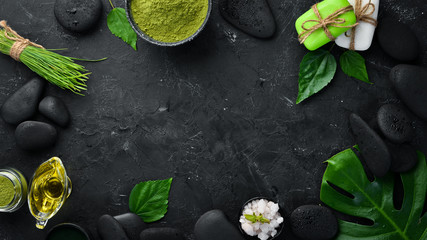 Zen stones and leaves with water drops. Spa background with spa accessories on a dark background....