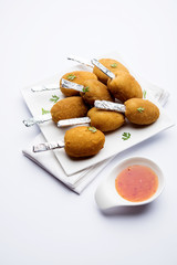 Crispy Veg lollipop recipe made using boiled potato with spices covered with corn flour and bread crumbs coating and then deep fried, served with toothpick or ice cream stock inserted in it with sauce
