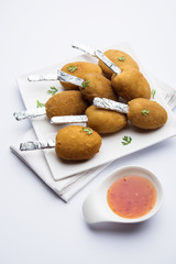 Crispy Veg lollipop recipe made using boiled potato with spices covered with corn flour and bread crumbs coating and then deep fried, served with toothpick or ice cream stock inserted in it with sauce