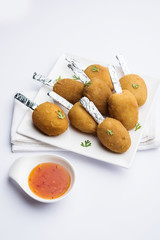 Crispy Veg lollipop recipe made using boiled potato with spices covered with corn flour and bread crumbs coating and then deep fried, served with toothpick or ice cream stock inserted in it with sauce