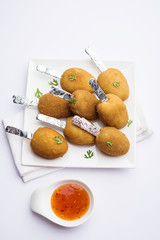 Crispy Veg lollipop recipe made using boiled potato with spices covered with corn flour and bread crumbs coating and then deep fried, served with toothpick or ice cream stock inserted in it with sauce