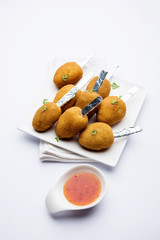 Crispy Veg lollipop recipe made using boiled potato with spices covered with corn flour and bread crumbs coating and then deep fried, served with toothpick or ice cream stock inserted in it with sauce