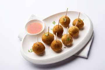 Crispy Veg lollipop recipe made using boiled potato with spices covered with corn flour and bread crumbs coating and then deep fried, served with toothpick or ice cream stock inserted in it with sauce