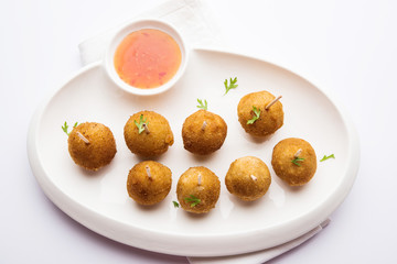 Crispy Veg lollipop recipe made using boiled potato with spices covered with corn flour and bread crumbs coating and then deep fried, served with toothpick or ice cream stock inserted in it with sauce