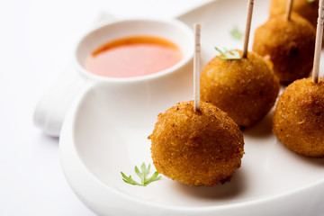 Crispy Veg lollipop recipe made using boiled potato with spices covered with corn flour and bread crumbs coating and then deep fried, served with toothpick or ice cream stock inserted in it with sauce
