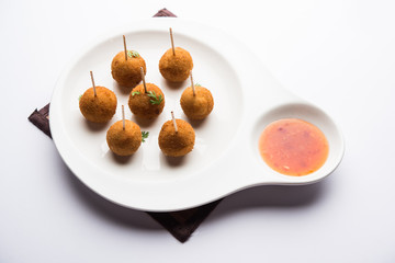 Crispy Veg lollipop recipe made using boiled potato with spices covered with corn flour and bread crumbs coating and then deep fried, served with toothpick or ice cream stock inserted in it with sauce
