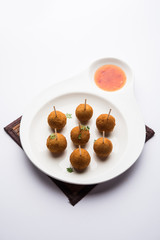 Crispy Veg lollipop recipe made using boiled potato with spices covered with corn flour and bread crumbs coating and then deep fried, served with toothpick or ice cream stock inserted in it with sauce
