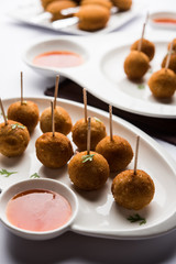 Crispy Veg lollipop recipe made using boiled potato with spices covered with corn flour and bread crumbs coating and then deep fried, served with toothpick or ice cream stock inserted in it with sauce
