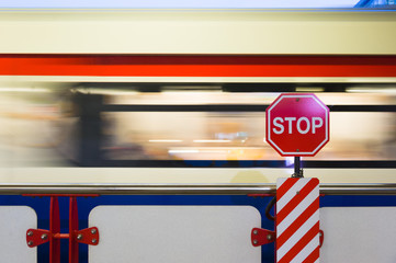 Stop sign board with moving train on background