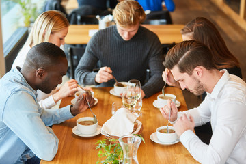 Young people eat soup together as a starter