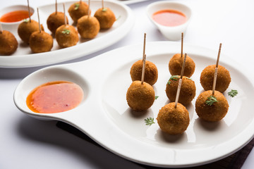 Crispy Veg lollipop recipe made using boiled potato with spices covered with corn flour and bread crumbs coating and then deep fried, served with toothpick or ice cream stock inserted in it with sauce