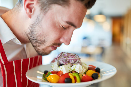 Waiter serving fresh greek salad - Powered by Adobe