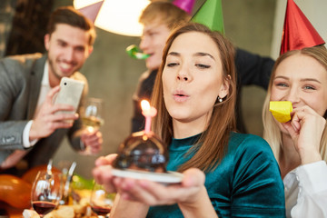 Woman blows out cake on birthday party