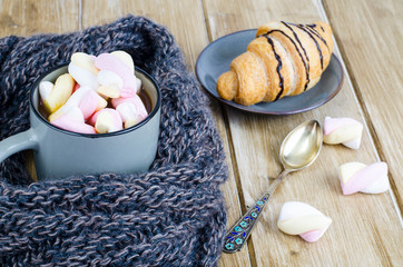 Cup of hot cocoa with marshmallows, woolen warm scarf, cozy winter evening