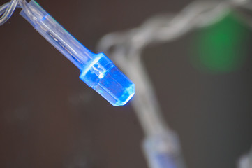 Blue light bulb Christmas garland close-up macro